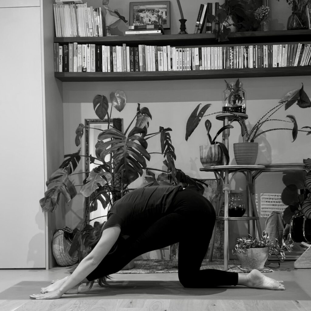 Personne en posture de yoga, ancrée et concentrée, dans une ambiance calme.