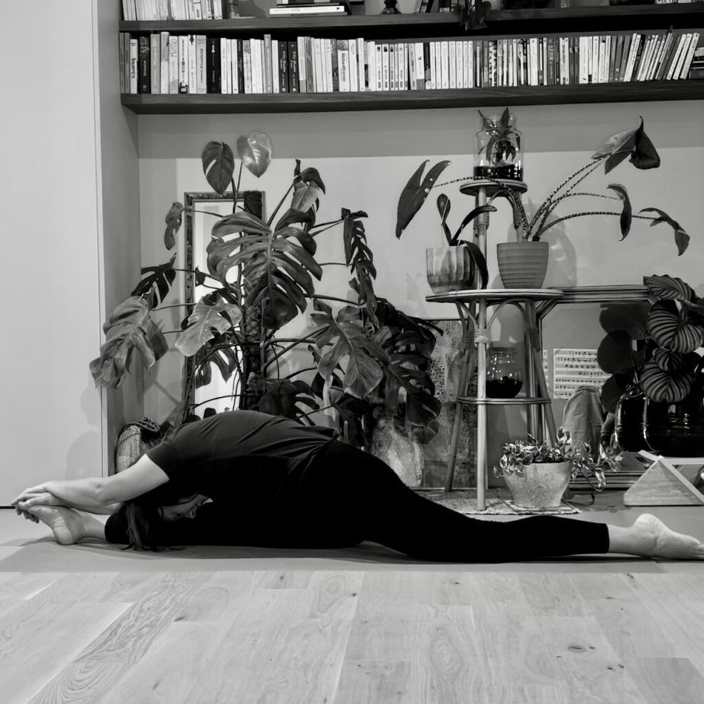 Personne en posture de yoga, ancrée et concentrée, dans une ambiance calme.